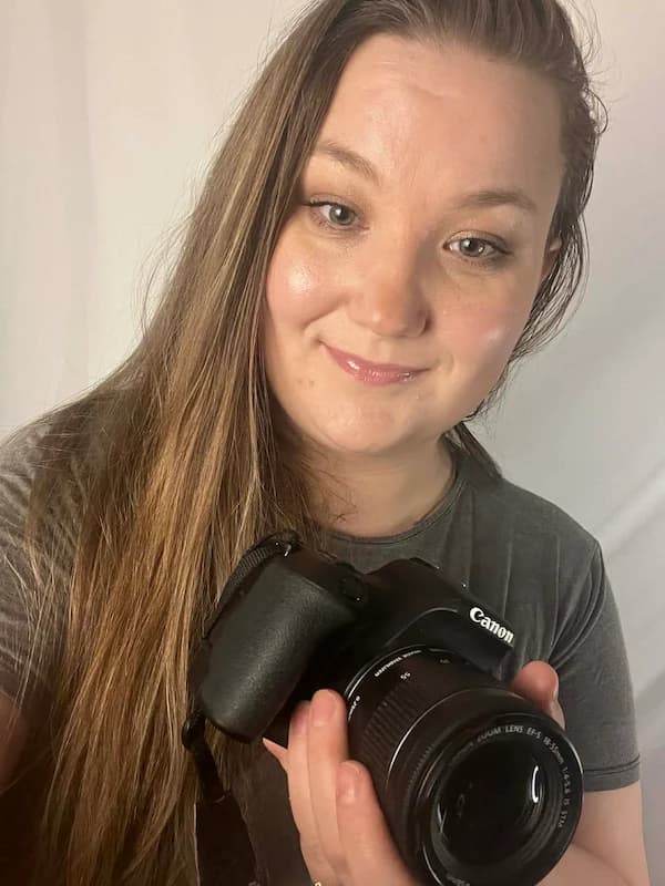 Fotografka Klaudia z usmiechem zajmujaca sie swoja praca w domowym studio.